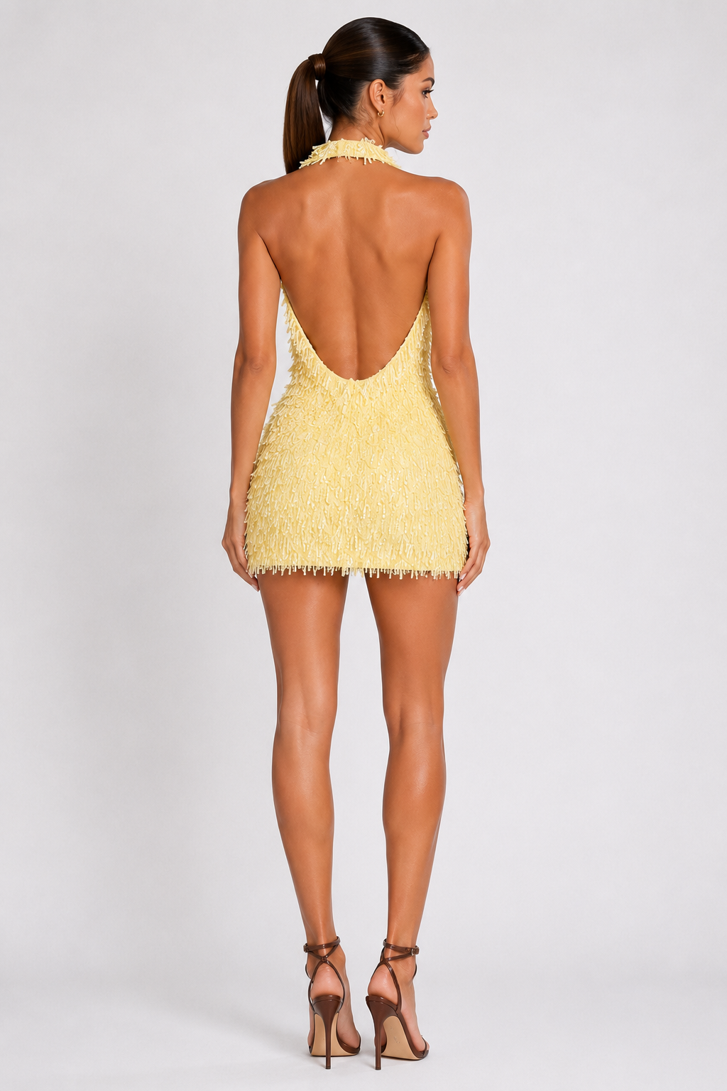 Vestido corto amarillo de flecos, de espalda descubierta